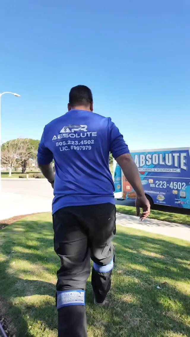 Absolute Plumbing crew member walking toward the company van