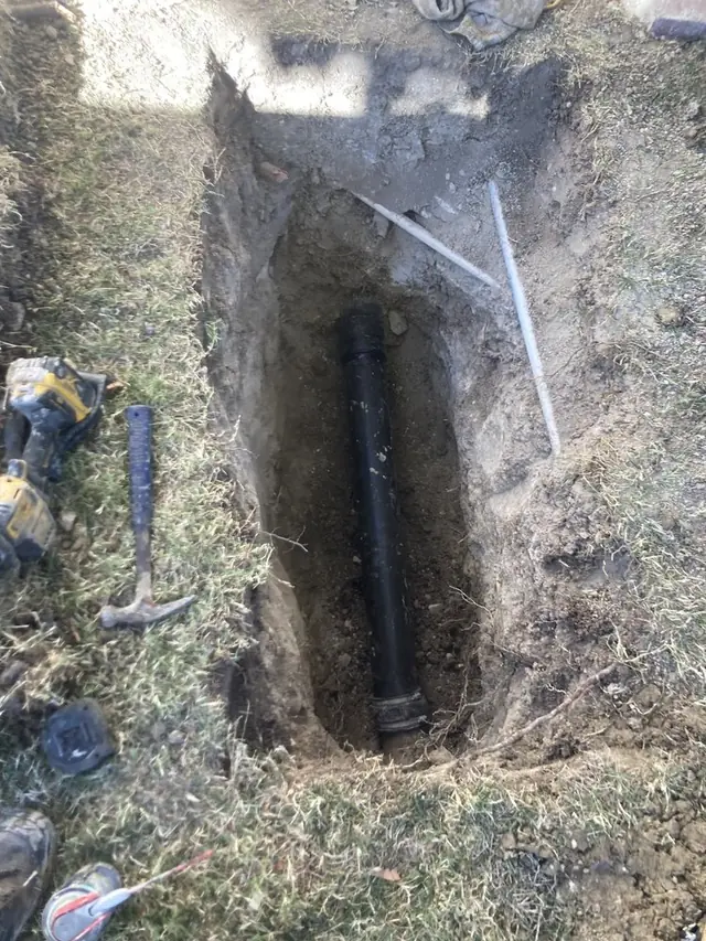 Excavated trench exposing a replaced sewer main line